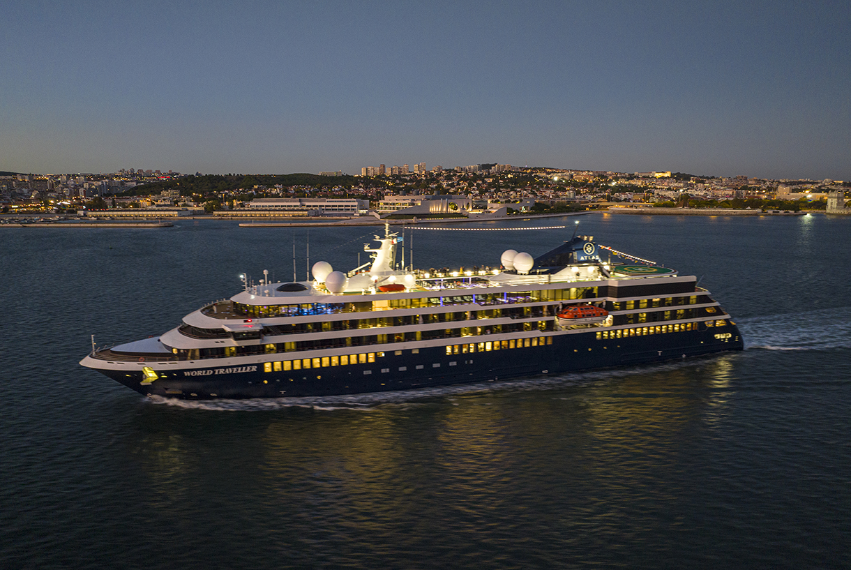 World Traveller ship sailing off the coast in the evening